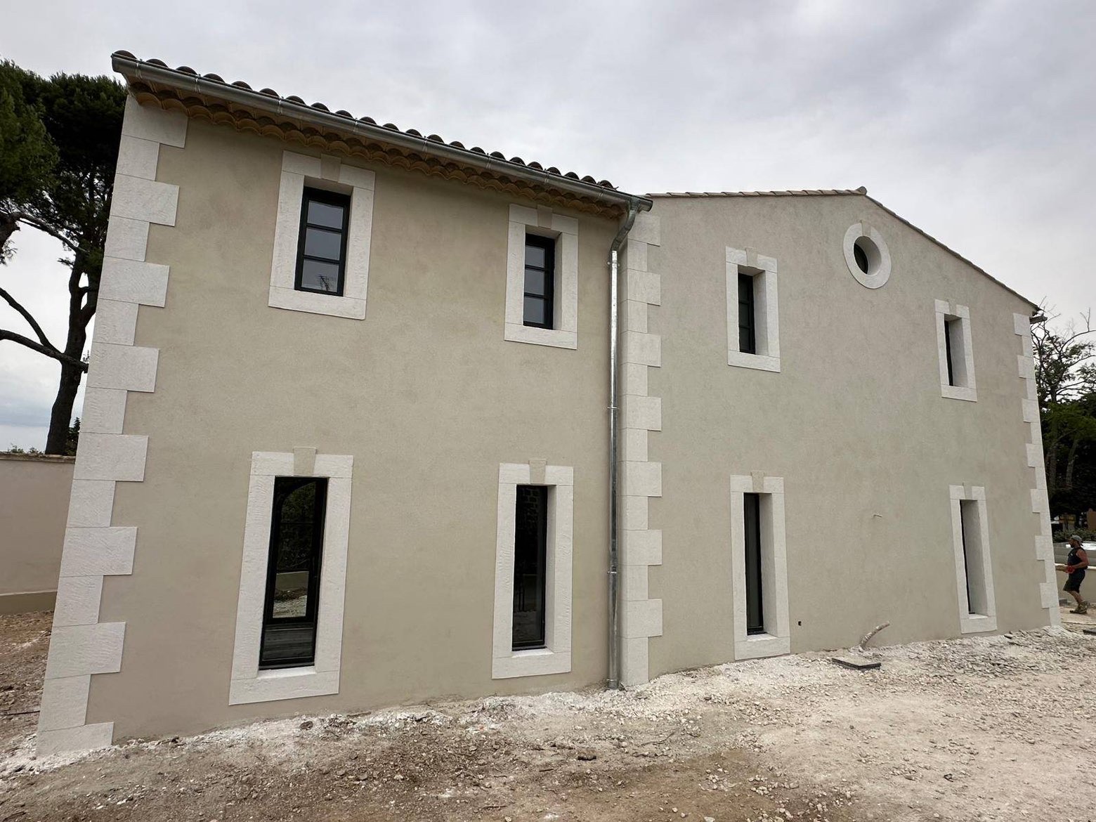 Enduit taloché avec bandeaux décoratifs autour des ouvertures